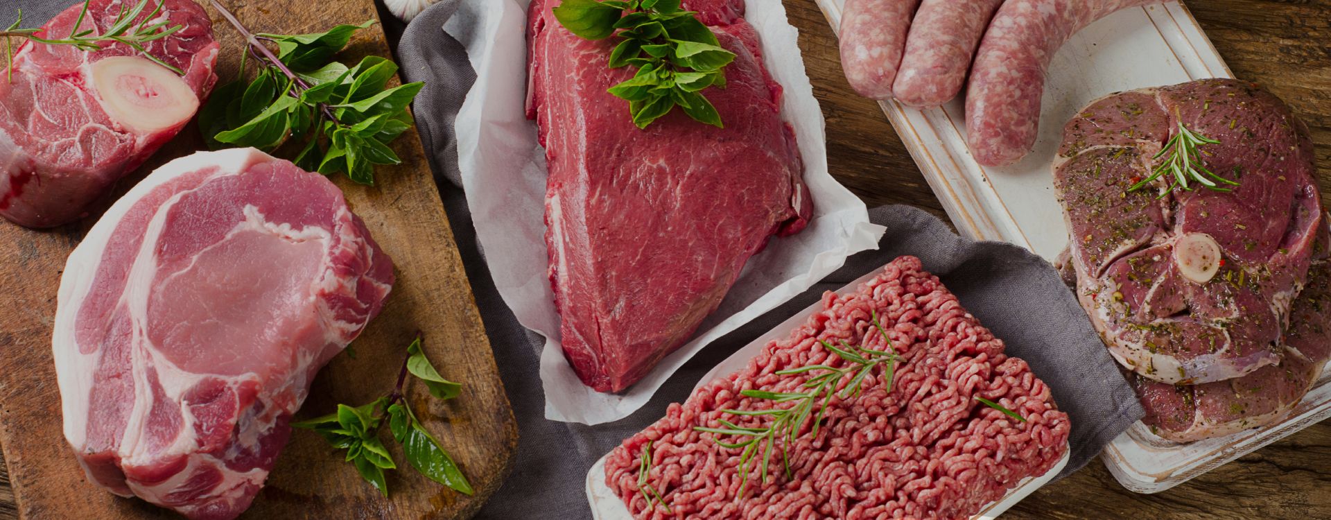 Different types of fresh raw meat on dark wooden background. Banner. Panorama